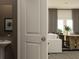 A bright hallway leading to a dining area with a modern table and chairs, and a glimpse of a sink at 2429 Livi Ln, Buford, GA 30519