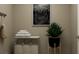 Cozy laundry room featuring a laundry hamper, stacked towels, and a potted green plant at 2429 Livi Ln, Buford, GA 30519
