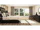 Tranquil bedroom featuring a plush bed, large windows, and dark furniture accents at 2429 Livi Ln, Buford, GA 30519