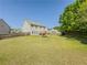 Expansive fenced backyard with a playset and lush green grass under a clear blue sky at 2775 Storybook Ct, Grayson, GA 30017