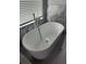 Modern freestanding tub with chrome faucet, set against a marble tile wall at 280 Ridge Bluff Ln, Suwanee, GA 30024