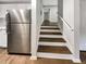 Kitchen with stainless steel refrigerator and adjacent staircase with hardwood steps at 4254 River Green Nw Dr # 612, Atlanta, GA 30327