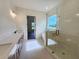 Bright bathroom featuring double vanities, a glass-enclosed shower, and a soaking tub at 6490 Mockingbird Rd, Cumming, GA 30028