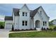 Striking two-story home with a white exterior, arched entrance, and manicured front lawn at 6490 Mockingbird Rd, Cumming, GA 30028