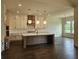 Spacious kitchen featuring a large island, white cabinets, and modern lighting at 6490 Mockingbird Rd, Cumming, GA 30028