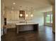Spacious kitchen featuring white cabinets, a large island, stainless steel appliances, and dark hardwood floors at 6490 Mockingbird Rd, Cumming, GA 30028