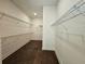 Spacious walk-in closet with multiple rows of wire shelving and wood-look flooring at 6490 Mockingbird Rd, Cumming, GA 30028