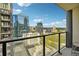 Relaxing balcony view with city buildings, clear blue skies, and metal framed seating for two at 1280 W Peachtree Nw St # 2801, Atlanta, GA 30309