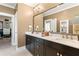 Bathroom features double sinks, sleek cabinetry, large mirror, and adjacent walk-in closet at 130 Inwood Walk, Woodstock, GA 30188