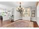 Elegant dining area with a large chandelier, a decorative rug, and an open view to the kitchen at 130 Inwood Walk, Woodstock, GA 30188