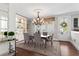 Elegant dining room boasts chandelier, built-in shelves, and views of outdoor greenery through a glass door at 130 Inwood Walk, Woodstock, GA 30188
