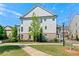 View of the rear of a three-story home with light gray siding and well-maintained landscaping at 130 Inwood Walk, Woodstock, GA 30188