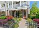 Inviting front entrance with rocking chairs, brick accents, and colorful landscaping along the walkway at 130 Inwood Walk, Woodstock, GA 30188