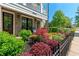 Beautifully landscaped front yard featuring lush plants, brick details, and an inviting outdoor seating area at 130 Inwood Walk, Woodstock, GA 30188
