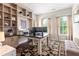 Bright home office featuring custom built-ins, a spacious desk, and a decorative rug with views to the outside at 130 Inwood Walk, Woodstock, GA 30188