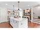 Bright kitchen with island, stainless appliances, seamlessly connected to staircase and living room at 130 Inwood Walk, Woodstock, GA 30188