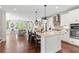 Bright kitchen boasts white cabinets, a large island with seating, and stainless steel appliances at 130 Inwood Walk, Woodstock, GA 30188