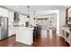 Bright kitchen boasts stainless steel appliances, a large island, and seamless flow into the living area at 130 Inwood Walk, Woodstock, GA 30188