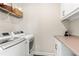 Laundry room with front load washer and dryer and upper cabinet storage at 130 Inwood Walk, Woodstock, GA 30188