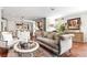 Open concept living room with hardwood floors, comfortable seating and access to the kitchen at 130 Inwood Walk, Woodstock, GA 30188