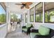 Inviting porch features comfortable seating, a ceiling fan, and views of the surrounding greenery at 130 Inwood Walk, Woodstock, GA 30188