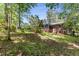 View of the rear of the property, with sunroom, lawn, and mature trees at 2357 Burnt Creek Rd, Decatur, GA 30033