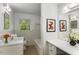 Bright bathroom featuring a single sink vanity, tiled walls, and natural light from a window at 2357 Burnt Creek Rd, Decatur, GA 30033