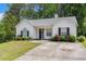 Quaint one-story home with a well-manicured lawn and blooming flower bushes at 25 Bridlewood Ct, Stockbridge, GA 30281