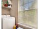 Well-lit laundry room with washer, shelving and a large window for natural light at 25 Bridlewood Ct, Stockbridge, GA 30281