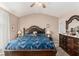 Spacious main bedroom featuring a tray ceiling, ceiling fan, and a large bed with ornate wood frame at 25 Bridlewood Ct, Stockbridge, GA 30281