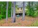 Backyard exterior with a wooden deck and outdoor seating, surrounded by trees at 7737 Bar Harbor Dr, Riverdale, GA 30296