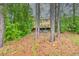 Backyard exterior with a wooden deck and outdoor seating, surrounded by trees at 7737 Bar Harbor Dr, Riverdale, GA 30296