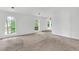 Bright bedroom featuring neutral walls, large arched windows, and cozy carpeting at 7737 Bar Harbor Dr, Riverdale, GA 30296