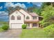 Inviting two-story home with a well-manicured lawn, attached garage, and lake view at 7737 Bar Harbor Dr, Riverdale, GA 30296