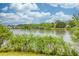 Scenic view of a calm lake surrounded by lush greenery and clear blue skies at 7737 Bar Harbor Dr, Riverdale, GA 30296