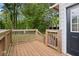 Outdoor deck with a wooden railing, stairs to yard, and door to house, surrounded by lush greenery at 808 Casplan Sw St, Atlanta, GA 30310
