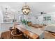 Open-concept dining area with modern lighting, wood floors, and seamless flow to the living room at 808 Casplan Sw St, Atlanta, GA 30310