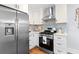 Stainless steel appliances and modern vent hood over gas range with stylish tiled backsplash at 808 Casplan Sw St, Atlanta, GA 30310