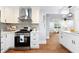 Modern kitchen with white cabinetry, stainless steel appliances, and decorative tile backsplash at 808 Casplan Sw St, Atlanta, GA 30310