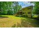 View of large backyard and side of the house with lots of mature trees in this tranquil outdoor space at 1131 Bailing Dr, Lawrenceville, GA 30043