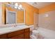 Bathroom with a single sink vanity, tub and shower combo, and orange textured walls at 1131 Bailing Dr, Lawrenceville, GA 30043