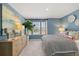 Well-lit bedroom with natural light, patterned bedding, and wood dresser at 2815 Habibi Ct, Buford, GA 30519