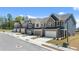 Exterior elevation of townhomes with two-car garages and professionally landscaped front yards on a sunny day at 2815 Habibi Ct, Buford, GA 30519
