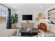 Living room featuring a comfortable sofa, black coffee table, media center, and woven wall art at 2815 Habibi Ct, Buford, GA 30519