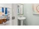 Stylish powder room featuring a pedestal sink, soft blue walls and decorative mirror at 2815 Habibi Ct, Buford, GA 30519