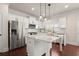 Open concept kitchen features a large kitchen island, stainless appliances, and white cabinets at 5760 Palmtree Pass, Cumming, GA 30040