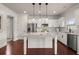 Open concept kitchen includes a spacious island with granite countertops, stainless steel appliances, and white cabinets at 5760 Palmtree Pass, Cumming, GA 30040