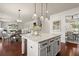 Lovely kitchen island features granite countertop, pendant lighting, and views of the living room and dining area at 5760 Palmtree Pass, Cumming, GA 30040