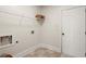 Bright laundry room with tile floors, shelving, and a white door at 5760 Palmtree Pass, Cumming, GA 30040