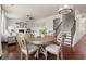 This open concept living area and breakfast nook have hardwood floors, an elegant light fixture, and a fireplace at 5760 Palmtree Pass, Cumming, GA 30040